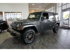 a gray jeep is parked in a showroom