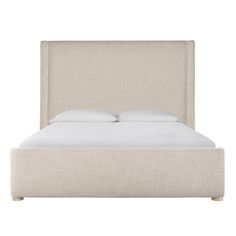 an upholstered bed with white linen