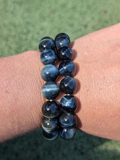 I have two very colorful larger bead size blue tiger's eye bracelets available. Blue Tigers Eye: Befitting the name, leave it to Tiger's Eye to be the stone you need when it's time to feel courageous. It awakens a braver side of you, but it does so in a way that isn't superficial. That's because self esteem and a deeper insight into yourself - your strengths and your weaknesses - is the kind of energy that Tiger's Eye offers. Confidence comes from just these kinds of insights, and so it's only natural you'll be braver for coming to terms with these sides of yourself.  With the blue verstion of tigers eye, it holds extra strength in the courage for proper communication. Proper Communication, Blue Tiger Eye Bracelet, Tigers Eye Bracelet, Eye Bracelets, Blue Tigers, Tiger Eye Bracelet, Blue Tigers Eye, Tigers Eye, Tiger's Eye