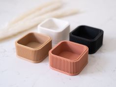 three small containers sitting on top of a white counter