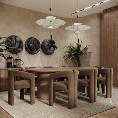 a dining room table surrounded by chairs in front of two wall hangings with art on them