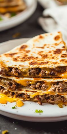 two quesadillas stacked on top of each other with cheese and meat in the middle