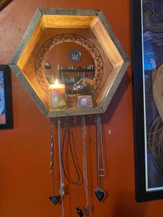 a clock hanging on the wall with a candle in front of it and other decorations