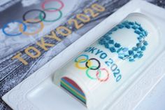 the tokyo olympics cake is decorated with blue and white frosting on it's base