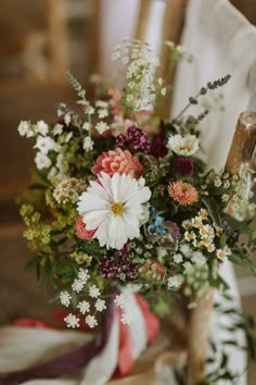 a bouquet of flowers sitting on top of a wooden chair