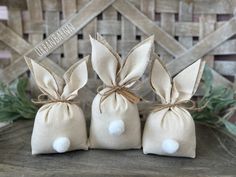 three small bags with bunny ears tied to each other on top of a wooden table