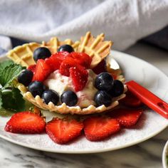 a white plate topped with waffles covered in fruit