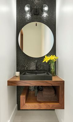 a bathroom with a sink, mirror and flowers in the vase on the counter top