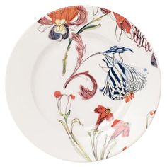 a white plate with red and orange flowers on it's rim, against a white background