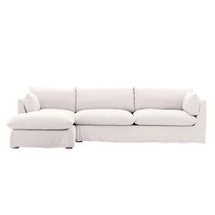 a white couch with a chaise lounger on the bottom right side and an ottoman in the middle