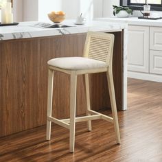 a white counter top sitting next to a wooden bar with a stool in front of it