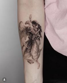 a woman's arm with an angel tattoo on the left side of her arm