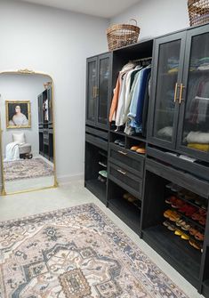 a walk - in closet with black cabinets and gold trimmings on the doors