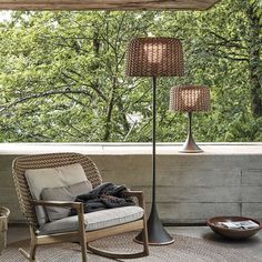 a chair sitting on top of a patio next to a lamp