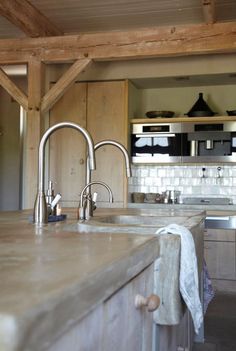 a kitchen with an island sink and wooden cabinets in the back drop off wall area