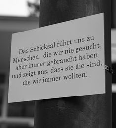 a sign attached to a pole with writing on it