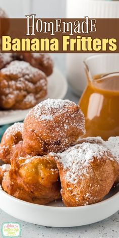 homemade banana fritters are piled on a plate with powdered sugar