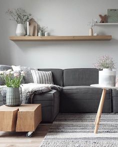 a living room with grey couches and wooden shelves on the wall, two people tried it