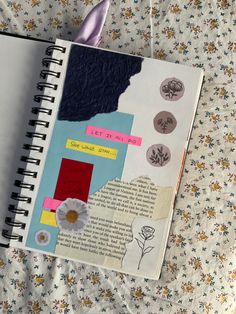 an open notebook with stickers on it sitting on top of a flowery bed