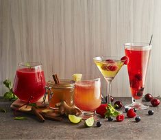 three glasses filled with different types of drinks and garnished with cherries, limes, lemon wedges, and cinnamon sticks