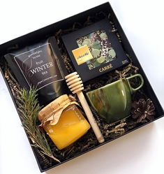 a gift box containing coffee, honey, soap and other personal care items with pine cones