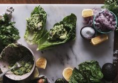 lettuce, lemons and other vegetables on a cutting board with salt and pepper