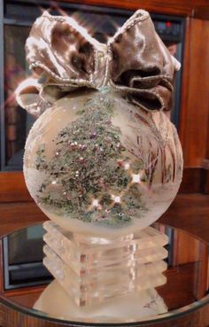 a glass ornament with a bow on top