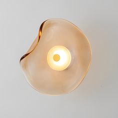 a light that is on the ceiling in a room with a white wall behind it