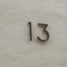 the number thirteen is written in black on a white wall