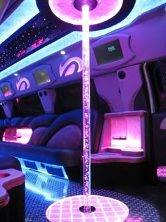 the inside of an airplane with purple and blue lights on it's seats,