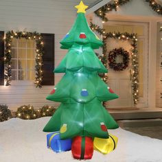 a lighted christmas tree in front of a house