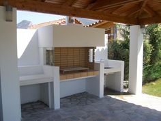 an outdoor bbq area with benches and tables