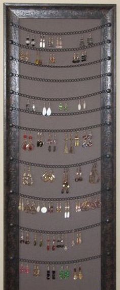 a wall mounted jewelry rack with many pairs of earrings