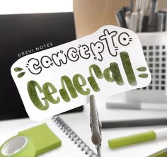 a green and white sign sitting on top of a desk next to a laptop computer