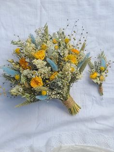 a bouquet of yellow and white flowers sitting on top of a table next to a napkin