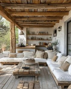 an outdoor living area with white couches and wooden tables