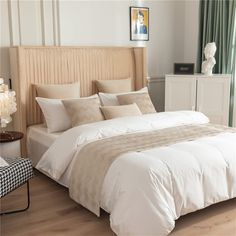 a bed with white sheets and pillows in a room