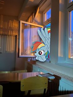 an image of a window with a rainbow pony face on the side and windows behind it