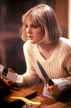 a woman sitting at a table with a calculator in her hand