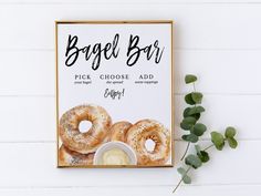 a box of bagel bars next to some green leaves on a white table top