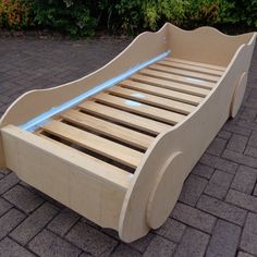 a wooden bed frame sitting on top of a brick floor