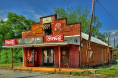 an old red brick building with coca cola signs on it