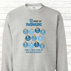 a sweatshirt that says, 12 days of swimming and a number of racing goggles