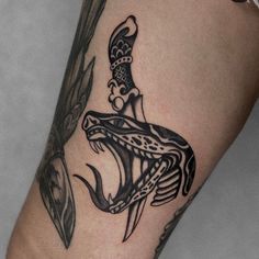 a black and white photo of a tattoo on someone's leg with a fish