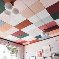 the ceiling is decorated with multicolored tiles and hanging light fixtures, along with pictures on the wall