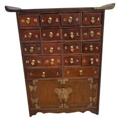 an old wooden chest with many drawers and gold decorations on the front, along with chinese characters