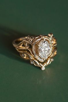 a close up of a ring on a green surface with a diamond in the center