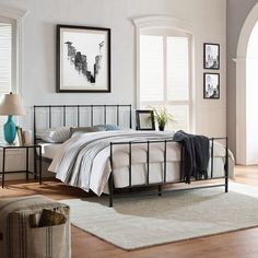 a bed room with a neatly made bed and pictures on the wall