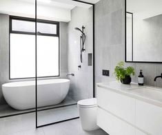 a bathroom with a tub, sink and mirror in it's centerpieces