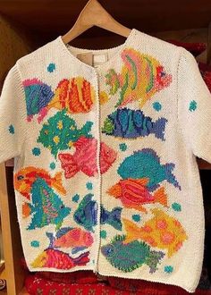 a white sweater with colorful fish on it